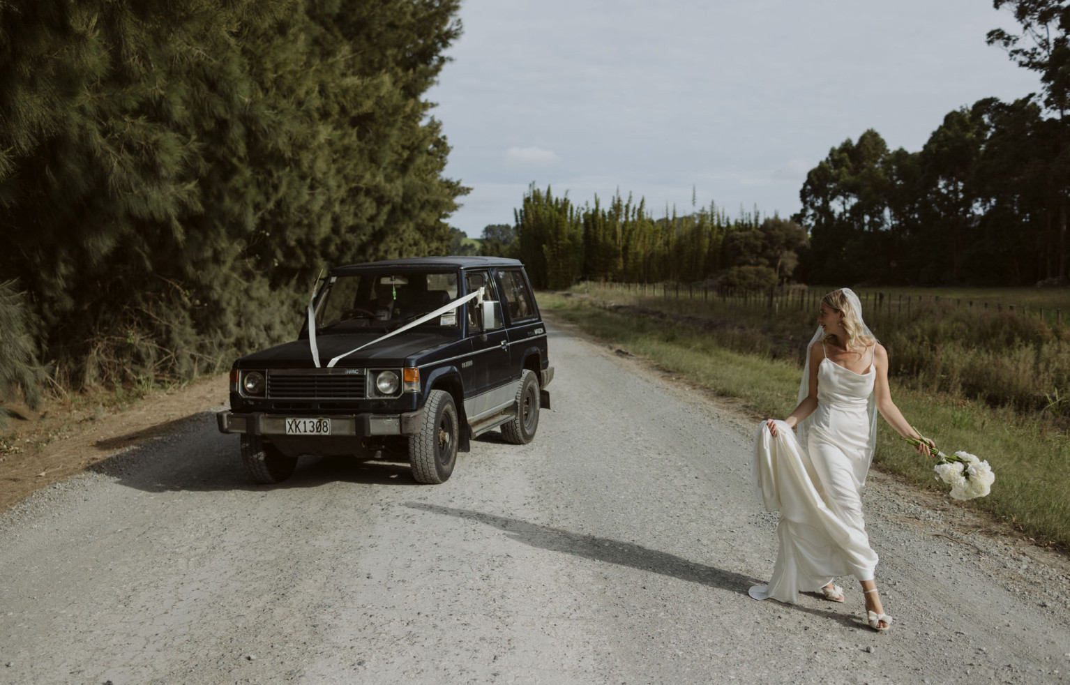 Wedding car and bride on dirt roads in Omaha