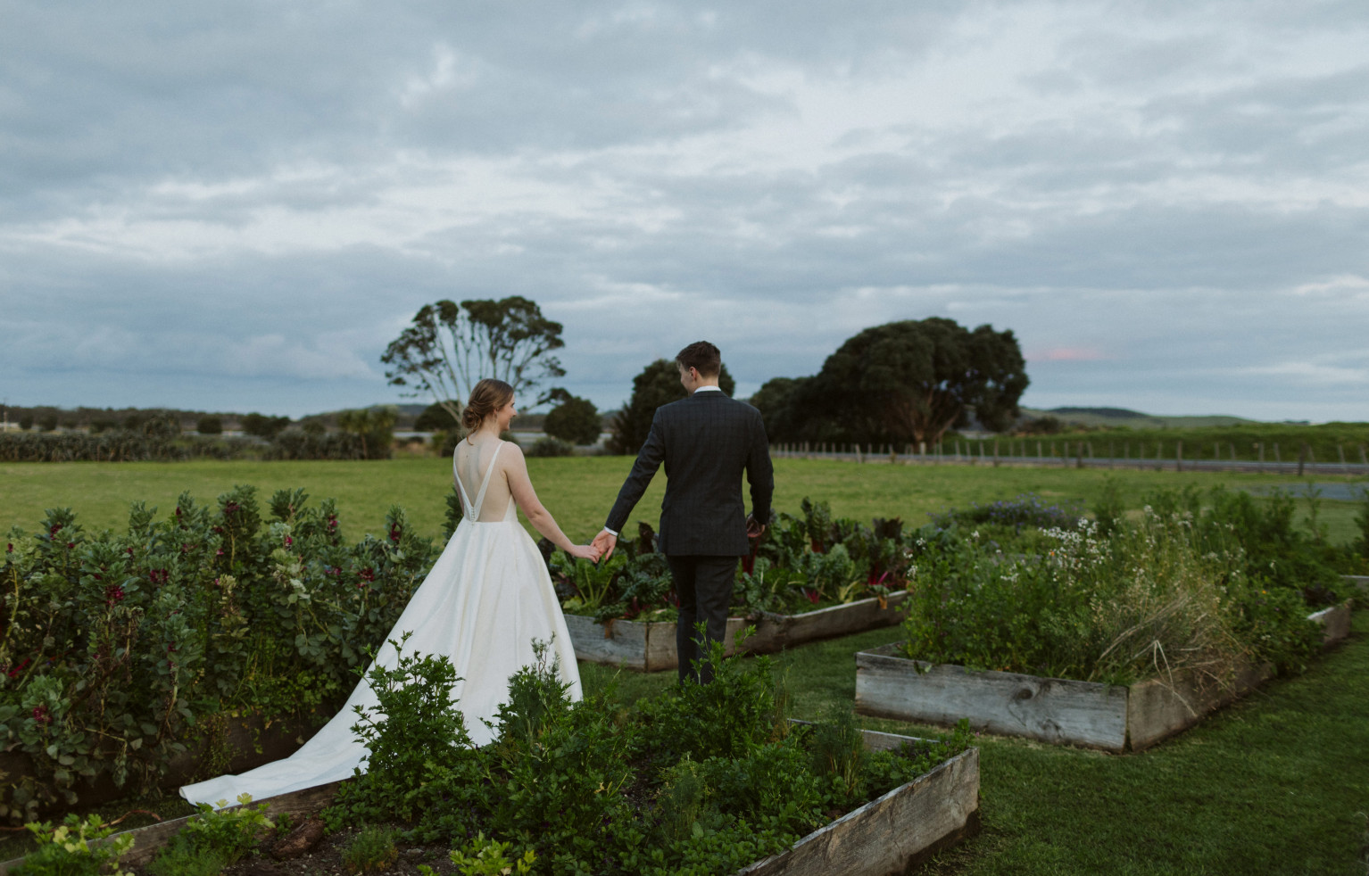 Bride and groom walking through vegetable gardens