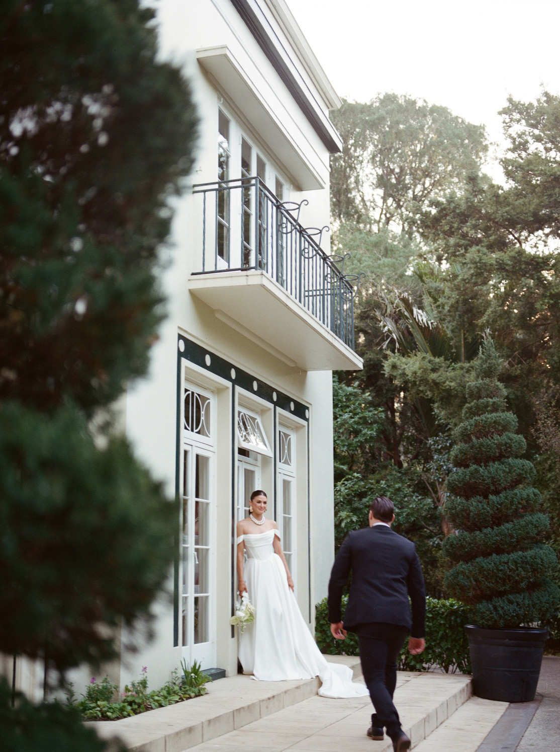 Bride and groom posing outside homestead